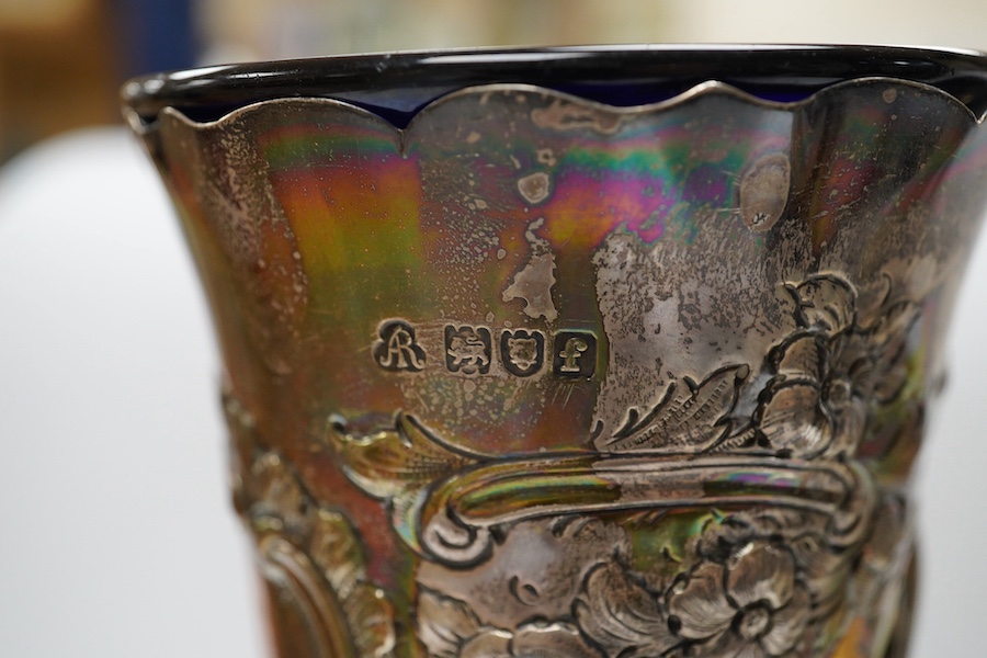 An Edwardian silver vase, embossed with hunting scene, with blue glass liner, Manoah Rhodes & Sons Ltd, London, 1901, 20.7cm, together with a German 800 white metal dish, on three supports. with damaged glass liner, 14.4